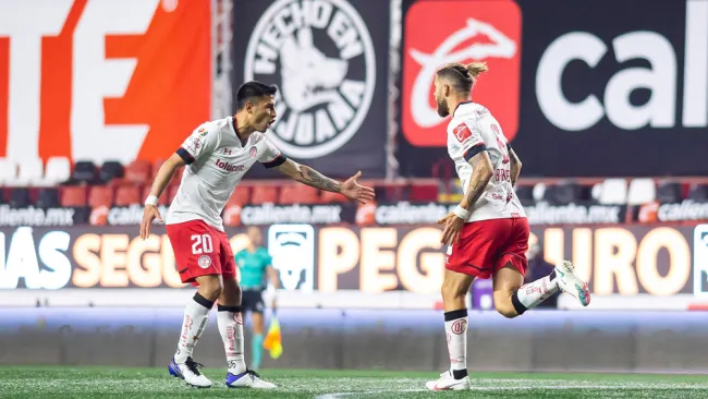 Claudio Baeza y Miguel Barbieri festejan un gol ante Xolos