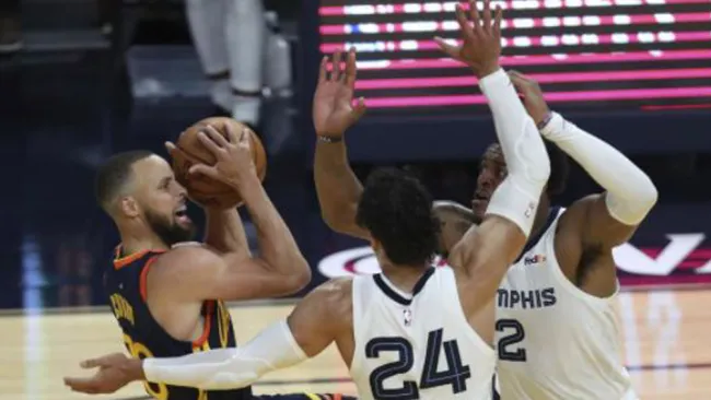 Stephen Curry es bloqueado por sus rivales