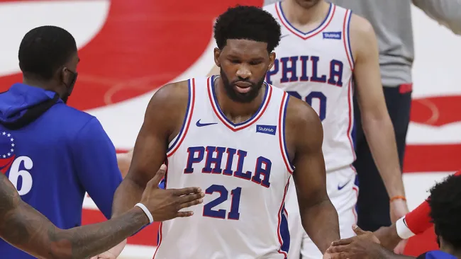 Joel Embiid es felicitado por sus compañeros 