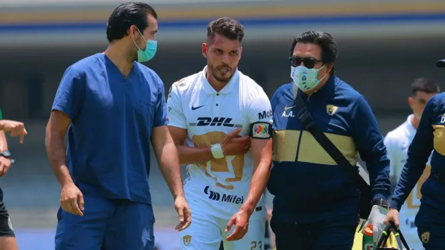 Nicolás Freire siendo atendido por los médicos en el duelo entre Pumas y Atlas