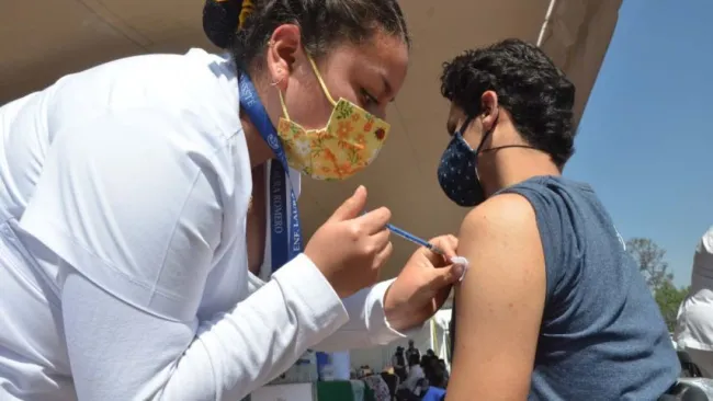 Enfermera vacunando a joven