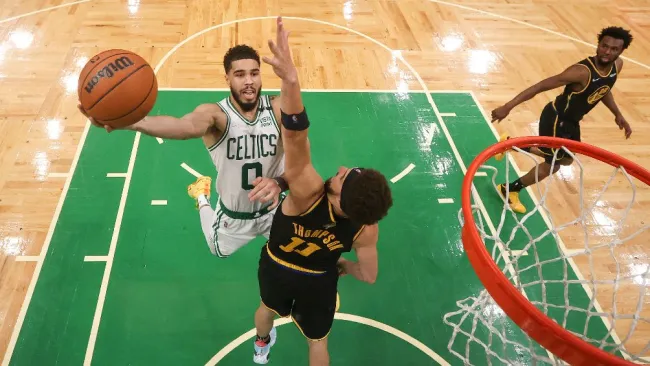 Jayson Tatum y Klay Thompson buscan el balón