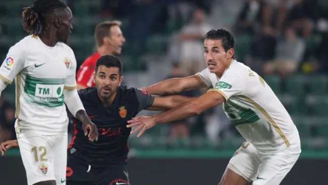 Jugadores del Elche y Mallorca disputando un balón