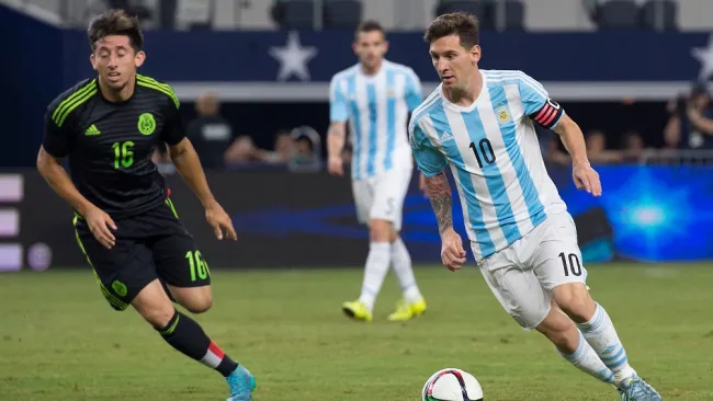 Messi disputa un balón con Héctor Herrera