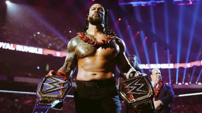 Roman Reigns con sus dos cinturones