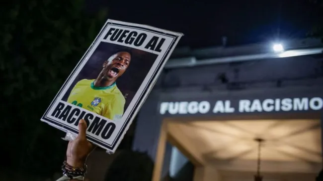 Manifestante sostiene una imagen del futbolista brasileño Vinicius Junior