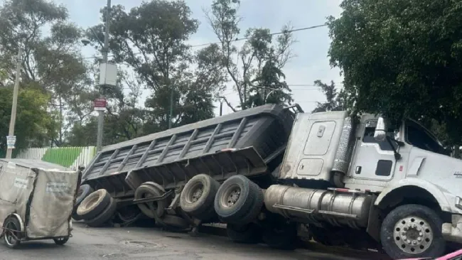 Un tráiler que transportaba piedras y tierra se cayó en un socavón.