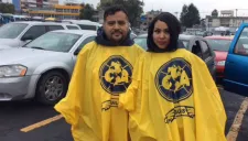 Aficionados muestran hasta en el impermeable su pasión por América