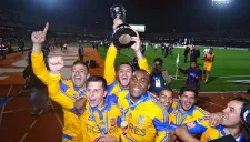 Jugadores de Tigres festejan con el trofeo de campeón