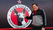 Miguel Herrera posa junto al logo de Xolos