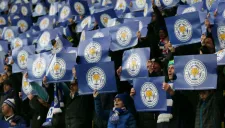 Aficionados del Leicester posan con pancartas del equipo