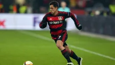 Chicharito conduce el balón en partido del Bayer