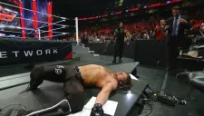 Roman Reigns observa a AJ Styles