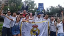 Aficionados merengues celebrando en la Fuente de la Cibeles