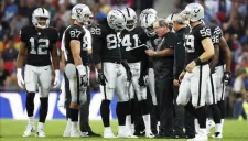 Jugadores de Raiders dialogan durante un encuentro de la NFL