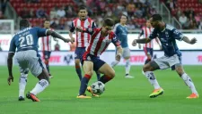 Isaac Brizuela intenta pasar entre dos jugadores rayados