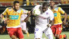 Luis Omar Hernández (amarillo y rojo) disputa un balón en juego de Herediano