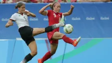 Josee Belanger y Annike Krahn disputan el balón durante el encuentro