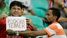 Un aficionado muestra un cartel donde se lee 'Fuera Temer'