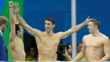 Michael Phelps (centro) festeja con sus compañeros el triunfo