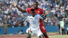 Romell Quioto pelea un balón con Doneil Henry