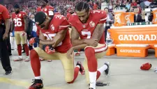 Colin Kaepernick y Eric Reid hincados durante el himno de EU
