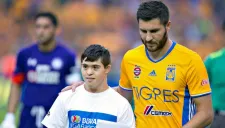 Gignac junto al niño que entregó el balón para el duelo entre Tigres y Cruz Azul