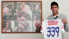 Juan José Calero posa junto a un cuadro con fotografías de su familia