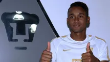 Fidel Martínez posa junto al escudo de Pumas