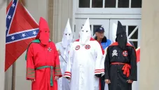 Miembros del Ku Klux Klan posan con una bandera confederada