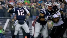 Tom Brady intenta lanzar un balón durante el juego frente a los Ravens