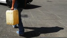 Un hombre trasporta gasolina en un contenedor