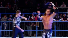 Johnny Impact festeja con el título en el centro del ring