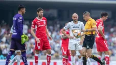 Árbitro toma el balón durante el partido