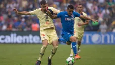 Guido Rodríguez disputa un balón ante Yotún de Cruz Azul