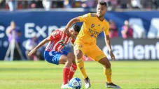 Jugadores del Atlético de San Luis y Tigres disputan un balón