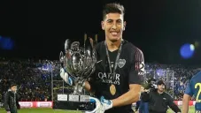 Esteban Andrada sostiene un trofeo que ganó con Boca Juniors