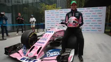 Checo Pérez posa con su casco y monoplaza