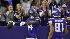 Stefon Diggs, receptor de Minnesota, festeja con su compañero Bisi Johnson