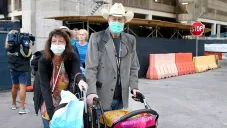 Un par de pasajeros usan cubrebocas por el coronavirus