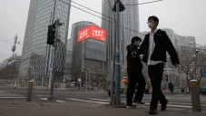 Residentes de Beijing caminan por sus calles protegidos con cubrebocas
