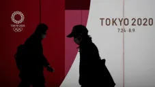 Ciudadanos de Tokio atraviesan por un anuncio de Tokio 2020