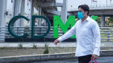 Persona camina en la Ciudad de México con cubrebocas