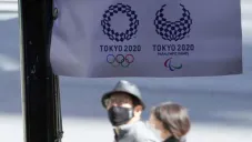 Habitantes de Japón pasan por un cartel de Tokio 2020