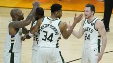 Jugadores de Bucks de Milwaukee festejan una canasta