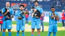 Jugadores del Zenit de San Petersburgo cargando a perros