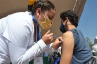 Enfermera vacunando a joven