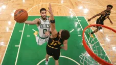 Jayson Tatum y Klay Thompson buscan el balón