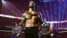 Roman Reigns con sus dos cinturones