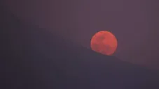 La luna hace su aparición detrás de las montañas
